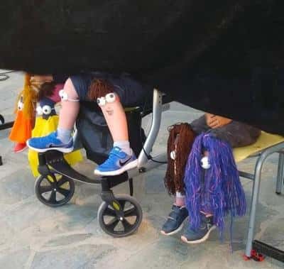 Παιδιά κάθονται με ψεύτικα μάτια και μαλλιά κολλημένα στα γόνατα.