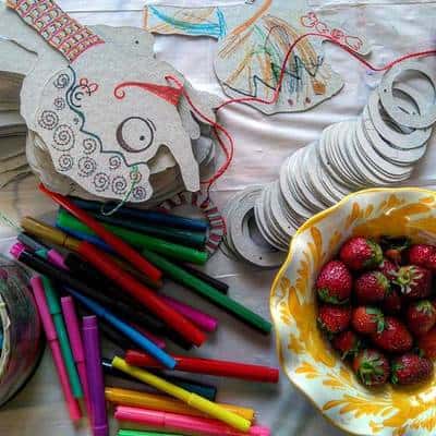 Μαρκαδόροι, χαρτιά και φραούλες πάνω σε τραπέζι.